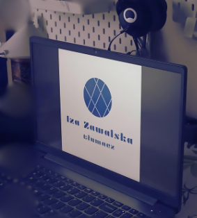 Biurko z laptopem wyświetlającym logo firmy Iza Zawalska tłumacz, w tle słowniki.